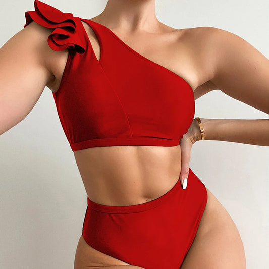 This image features the striking Lara One-Shoulder Bikini in a bold red color. The bikini is designed with a unique one-shoulder top that has a distinctive frill detail on the shoulder